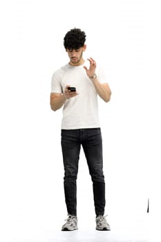 A man, on a white background, in full height, with bags and a phone.