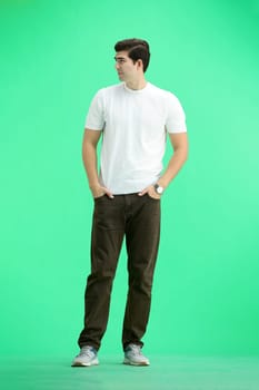 A man, full-length, on a green background.