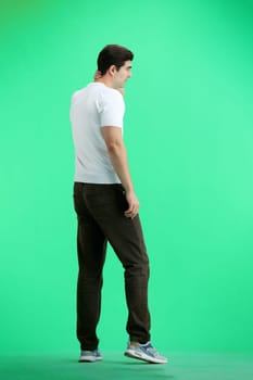 A man, full-length, on a green background, tired.