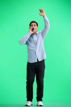 A man, full-length, on a green background, rejoices.