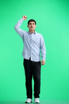 A man, full-length, on a green background, rejoices.