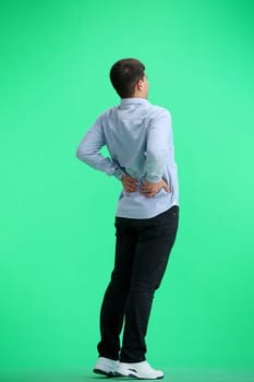 A man, full-length, on a green background, warming up.