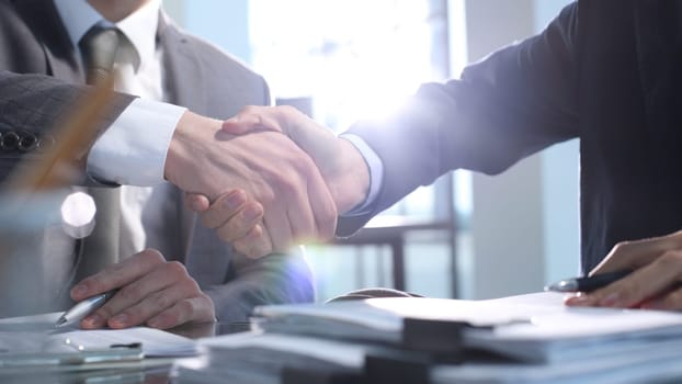 Signing documents at a meeting, business handshake.