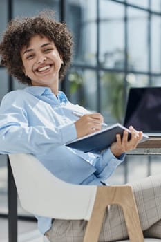 Smiling confident business leader looking at camera and standing in an office