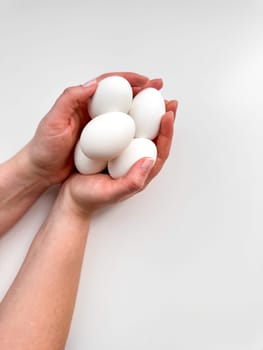 Hands cradling a cluster of white eggs against pale background, a symbol of care, nourishment, and new beginnings with ample copy space. For culinary websites, recipe blogs, and nutritional guides. High quality photo