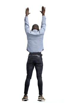 A man, full-length, on a white background, raised his hands up.