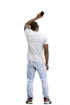 A man, full-length, on a white background, waving his phone.