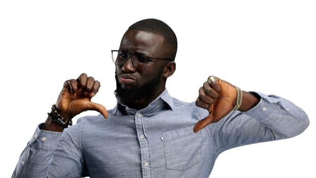 A man, close-up, on a white background, shows his thumbs down.