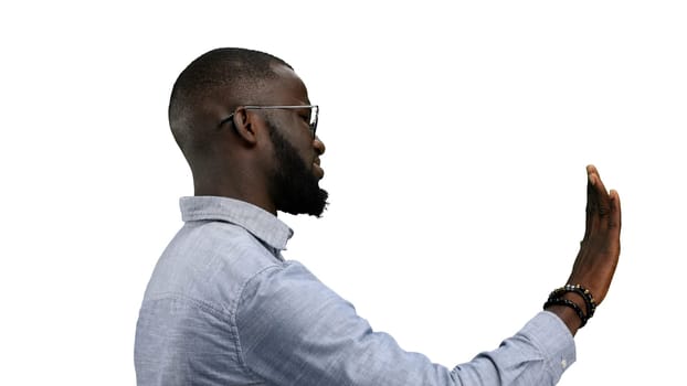 A man, close-up, on a white background, shows a stop sign.