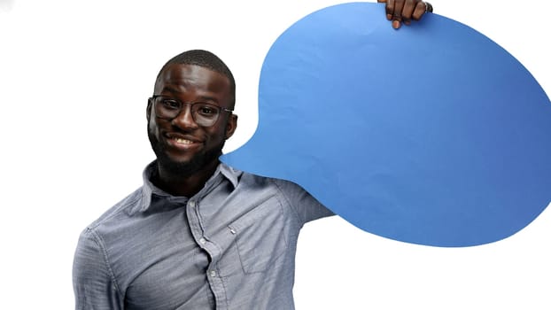 A man, close-up, on a white background, shows a blue comment sign.