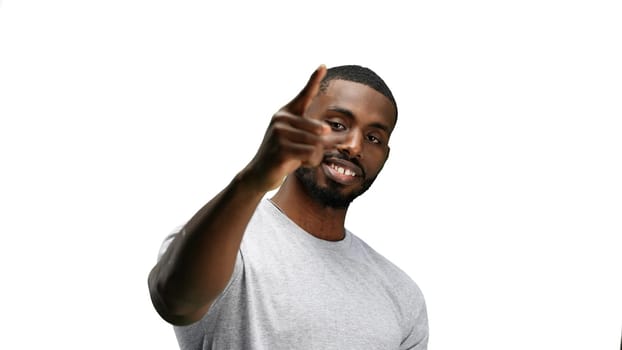 A man, close-up, on a white background, points forward.