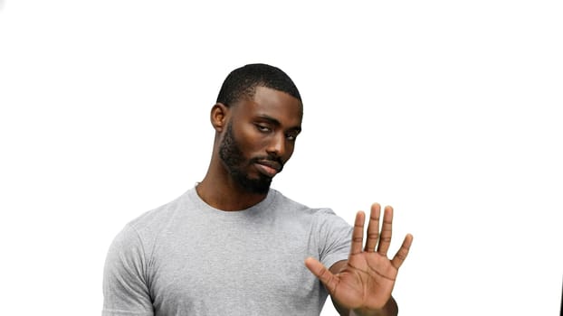 A man, close-up, on a white background, shows a stop sign.