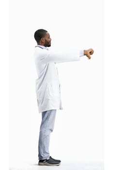 The doctor, in full height, on a white background, shows his thumbs down.