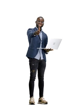 A man, full-length, on a white background, uses a laptop.