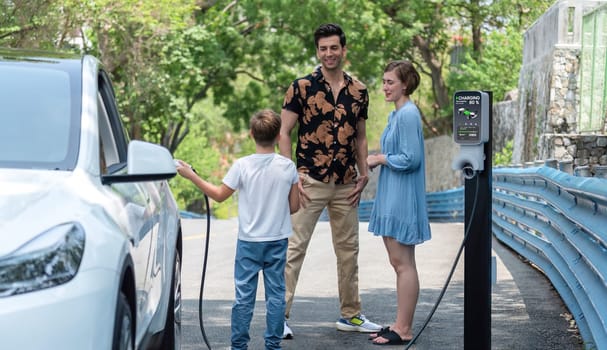 Family road trip vacation with electric vehicle, lovely family recharge EV car with green and clean energy. Natural and eco friendly car travel for sustainable environment. Perpetual