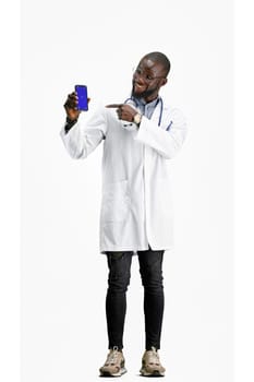 The doctor, in full height, on a white background, shows the phone.