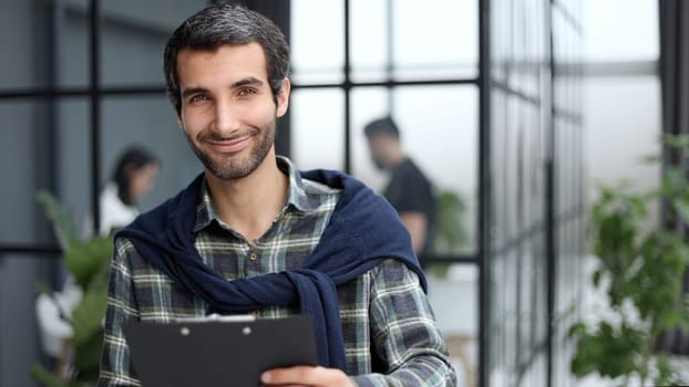 Stylish young businessman with a folder of documents in his hands.