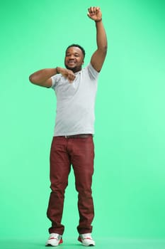 A man, full-length, on a green background, rejoicing.