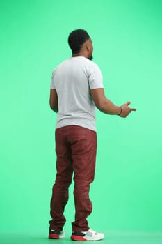 Man, full-length, on a green background, spreads their arms.