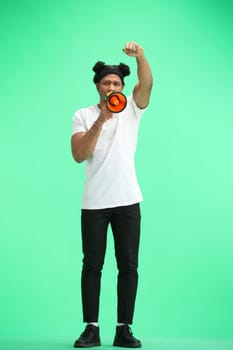 A man, full-length, on a green background, with a megaphone.