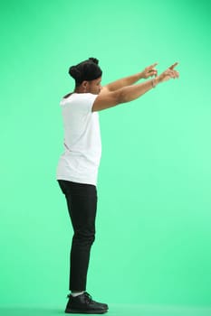 A man, full-length, on a green background, waving his arms.