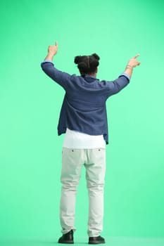 A man, full-length, on a green background, waving his arms.