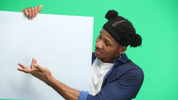 A man, close-up, on a green background, shows a white sheet.