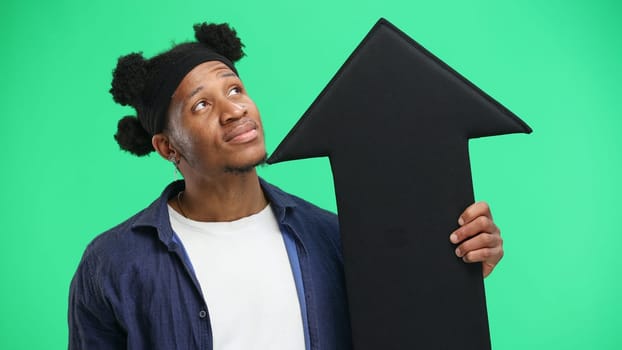 Man, close-up, on a green background, pointing up arrow.