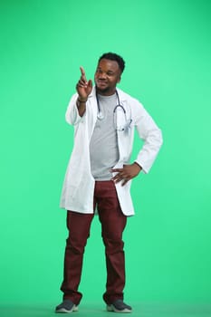 The doctor, in full height, on a green background, shows a forbidding sign.