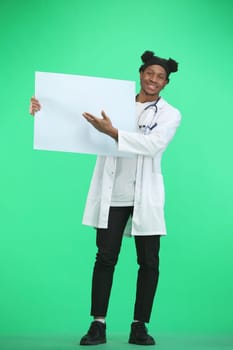 The doctor, in full height, on a green background, shows a white sheet.