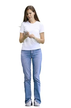 A woman, full-length, on a white background, with a phone.