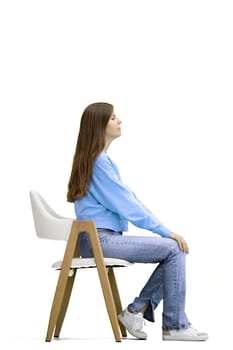 A woman, full-length, on a white background, sitting on a chair.