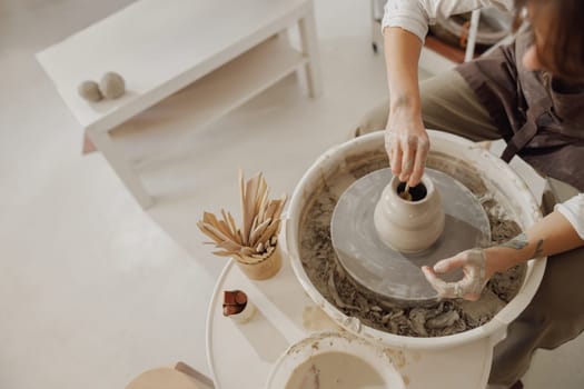 Close up of artisan's hands shaping clay bowl in pottery studio. Pottery art and creativity