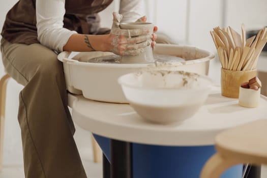 Close up of artisan's hands shaping clay bowl in pottery studio. Pottery art and creativity