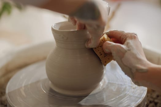 Close up of artisan's hands shaping clay bowl in pottery studio. Pottery art and creativity