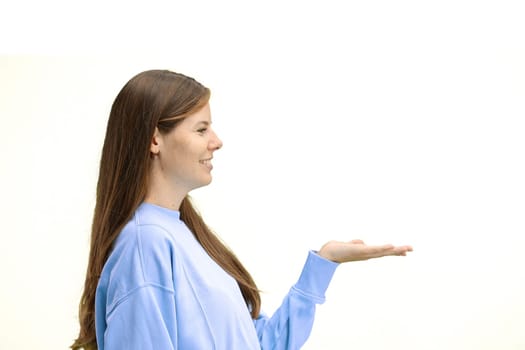 A woman, close-up, on a white background, points to the side.