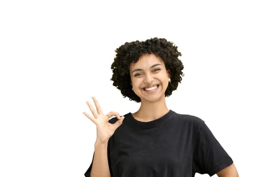 A woman, close-up, on a white background, shows an ok sign.