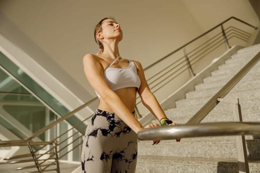 Young sportswoman in tracksuit is stretching outdoor and preparing to jogging. Healthy life concept