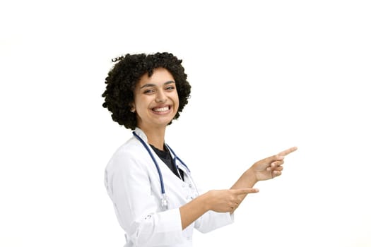 Female doctor, close-up, on a white background, pointing to the side.