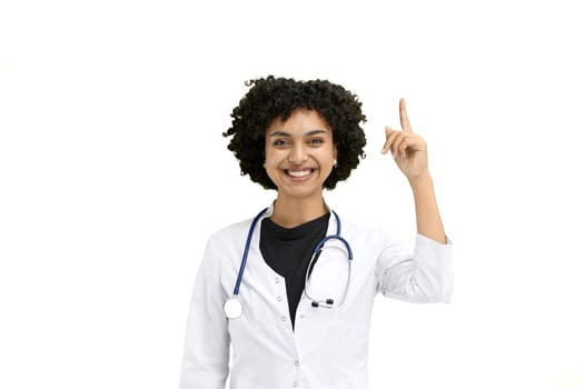 Female doctor, close-up, on a white background, pointing up.