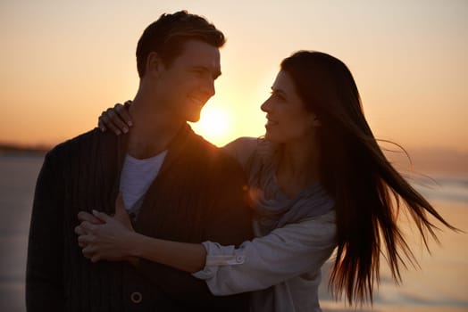 Couple hug, sunset on beach and travel for bonding, romance outdoor with love and trust. Happiness, support and loyalty with people in relationship, sunshine and adventure together with smile.