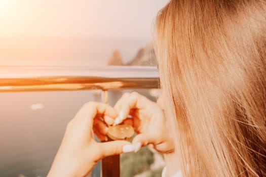 Hand, lock, heart, love, valentines day. Close up view of a woman holding a heart shaped lock that is locked onto a chain link fence.