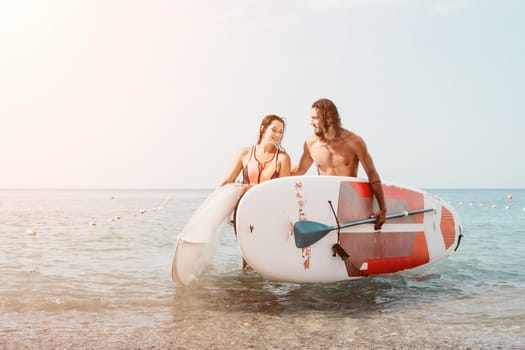 Woman man sea sup. Close up portrait of beautiful young caucasian woman with black hair and freckles looking at camera and smiling. Cute woman portrait in a pink bikini posing on sup board in the sea