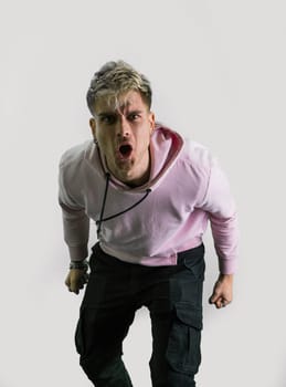 A man is pictured wearing a pink shirt and black pants. He stands confidently with his hands in his pockets, showcasing a casual yet stylish look, screaming to the camera