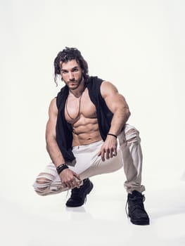 A shirtless man stands confidently, striking a pose for a photo. His muscular physique is on display as he looks directly at the camera, exuding a sense of strength and self-assurance.