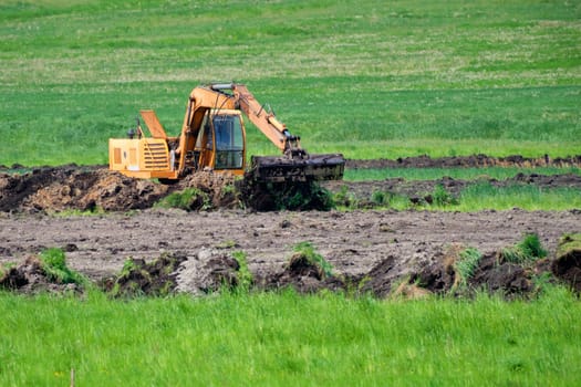 An excavator digs the ground to lay pipes