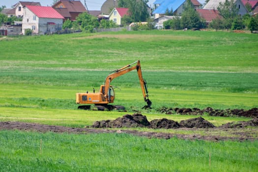An excavator is digging the ground in the distance