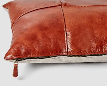 Artisanal couch pillow of hand-sewn smooth brown leather squares and grey linen back completed with convenient side zipper for added style and comfort, closeup view