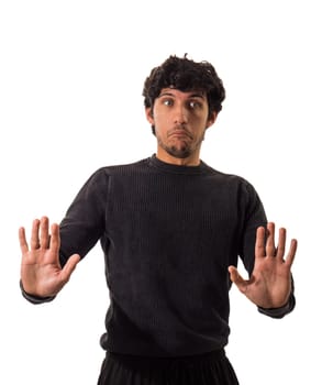 A man wearing a black sweater is standing and extending his hands outward in a straightforward gesture.