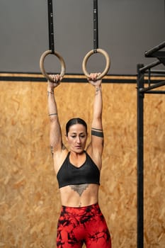 Vertical photo of a women training olympic ring in cross training center